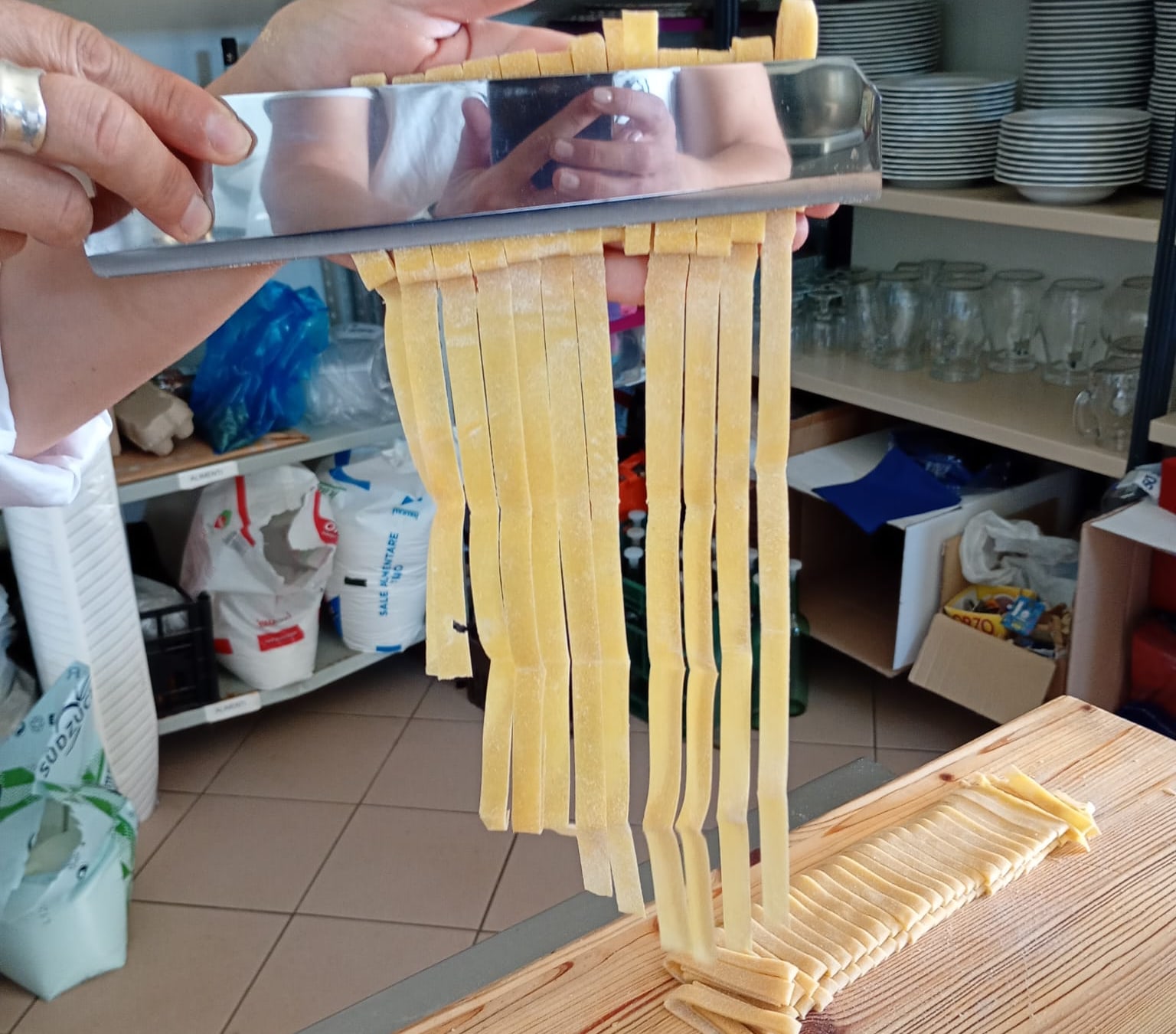 Il coltello solleva le tagliatelle appena tagliate